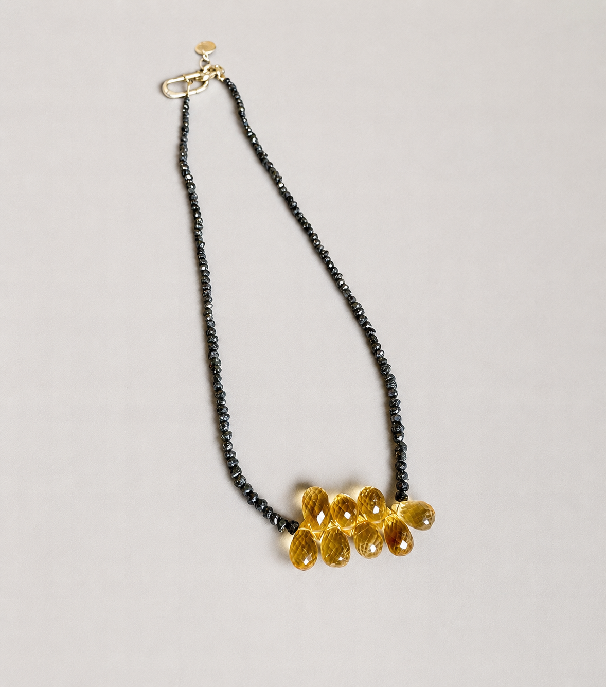 Necklace with black diamonds and citrino on a light gray background