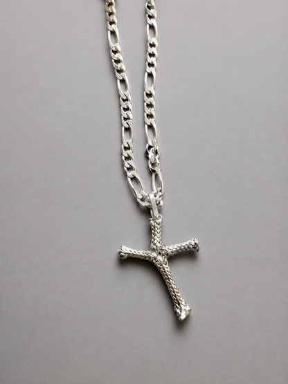 Silver cross necklace on a gray background